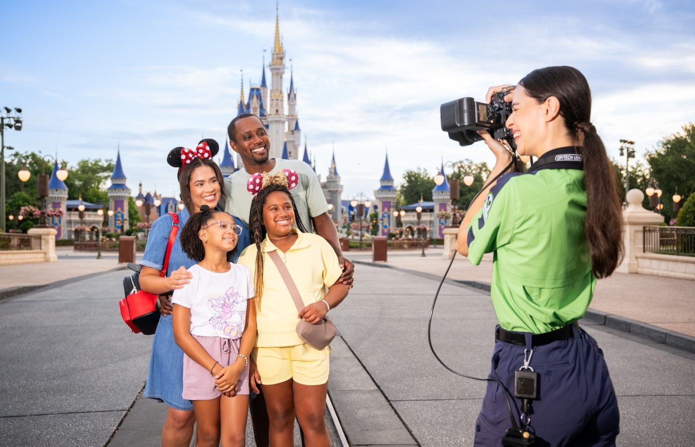 Familia con el castillo de Cenicienta de fondo mientras un fotógrafo de PhotoPass les toma una foto